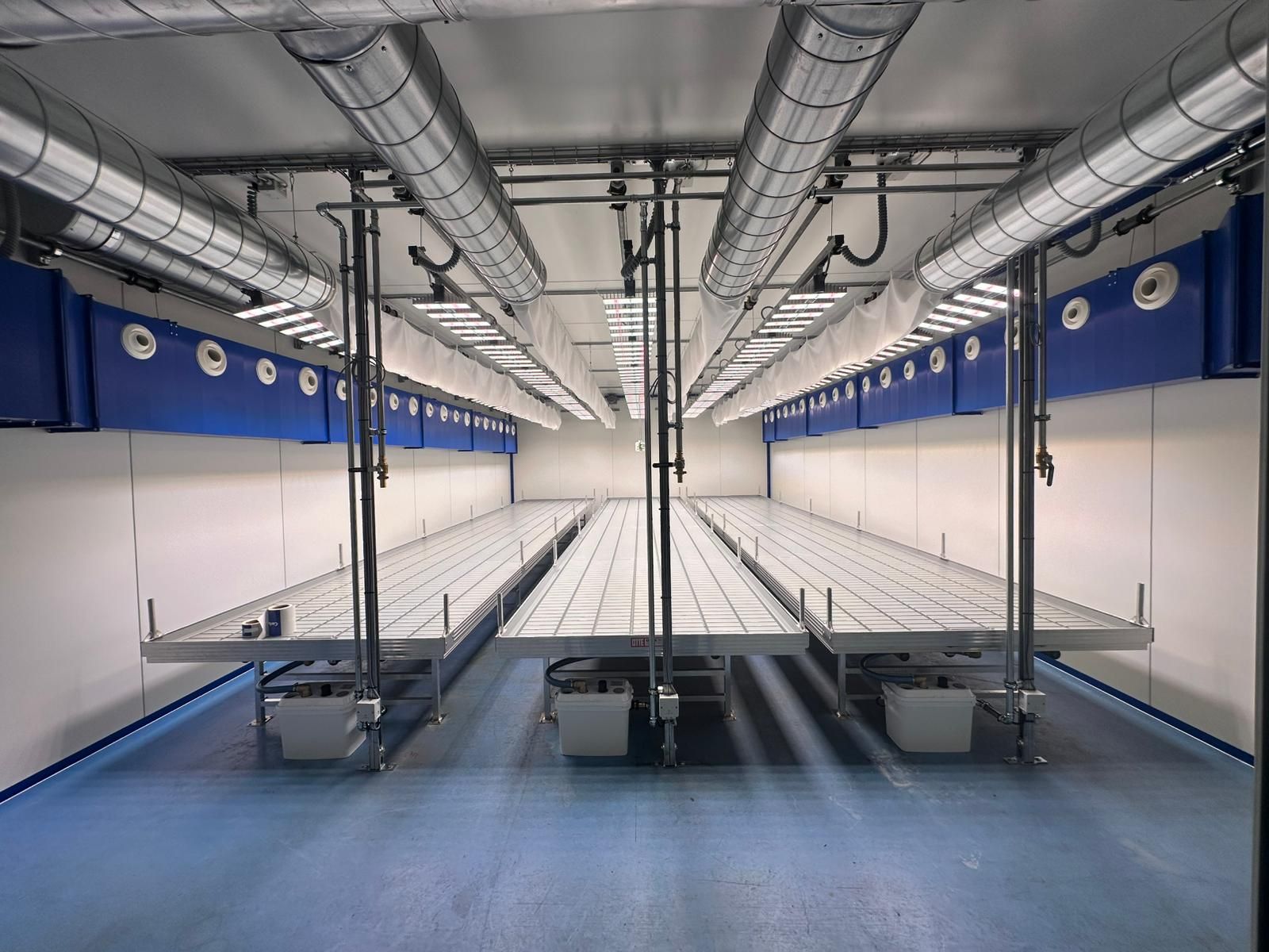 Lüftungsleitungen in einer grossen Halle mit Pflanztischen