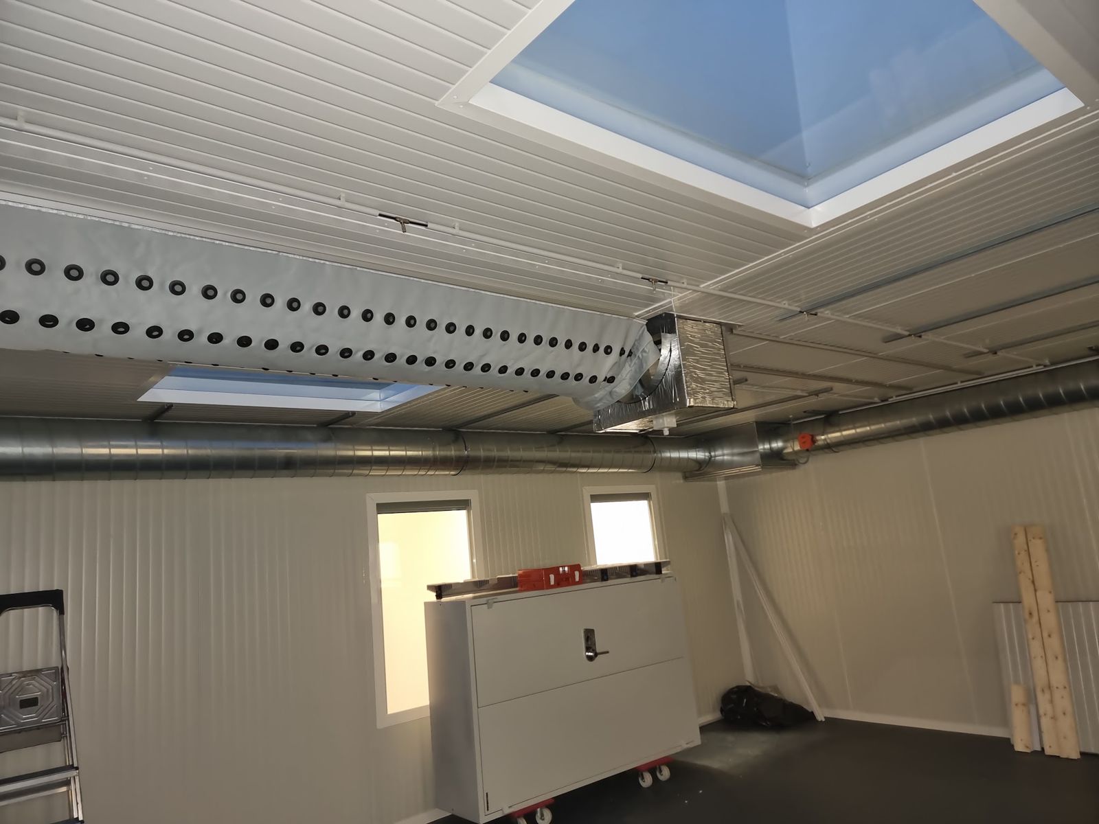 Lüftungsrohr unter einer Paneeldecke mit Lichtkuppel